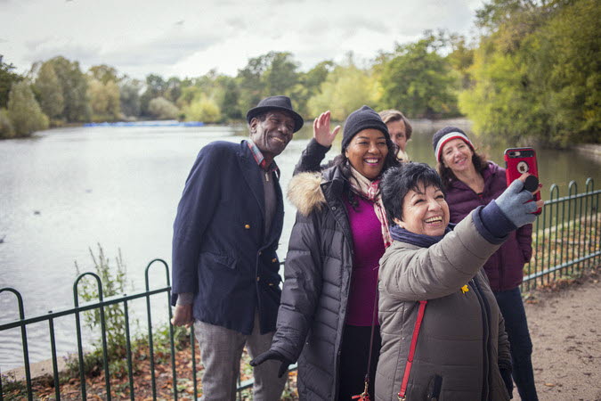 En grupp människor som tar en selfie i en park