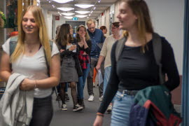 Studenter som rör sig fram i en korridor.