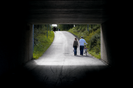 Två personer gåendes, fotograferat genom en viadukt
