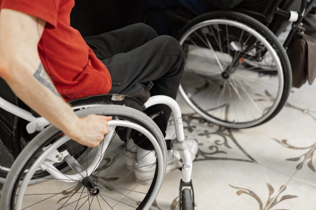 Bild på person i rullstol tagen från överkroppen och nedåt. 