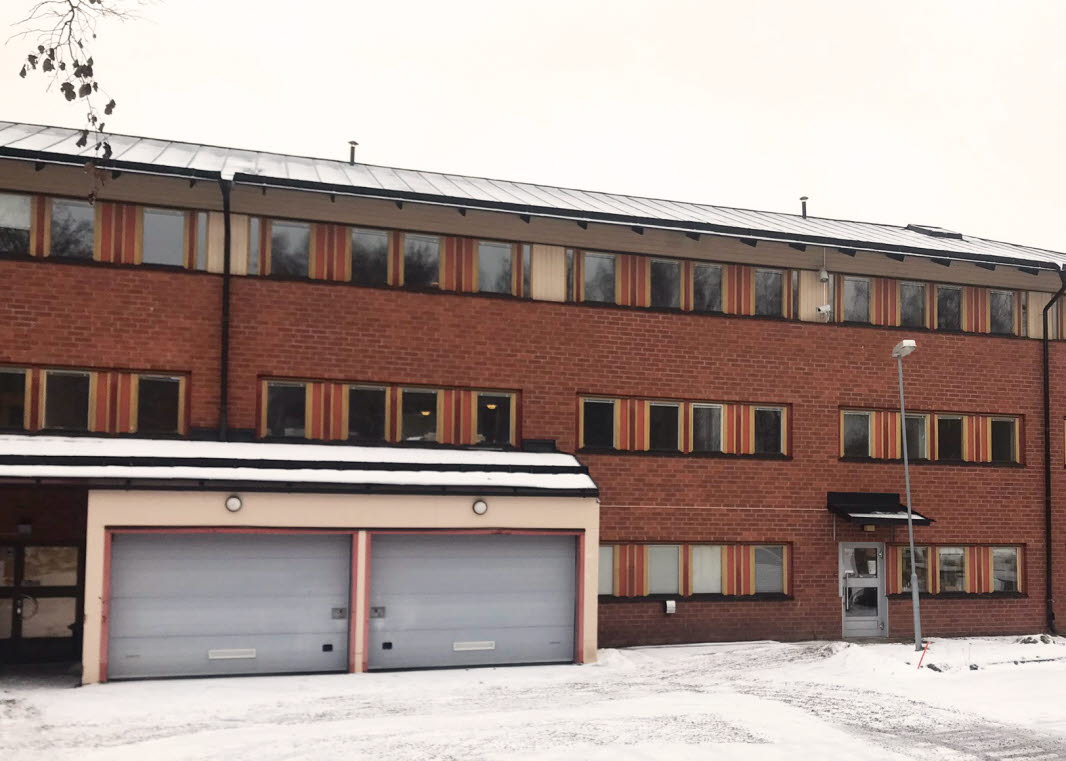 Kontorshus i rött tegel i tre plan med två garage.