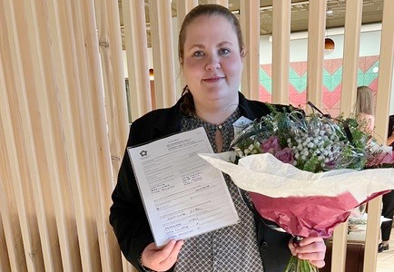 Person kvinna håller blommor dokument står inomhus