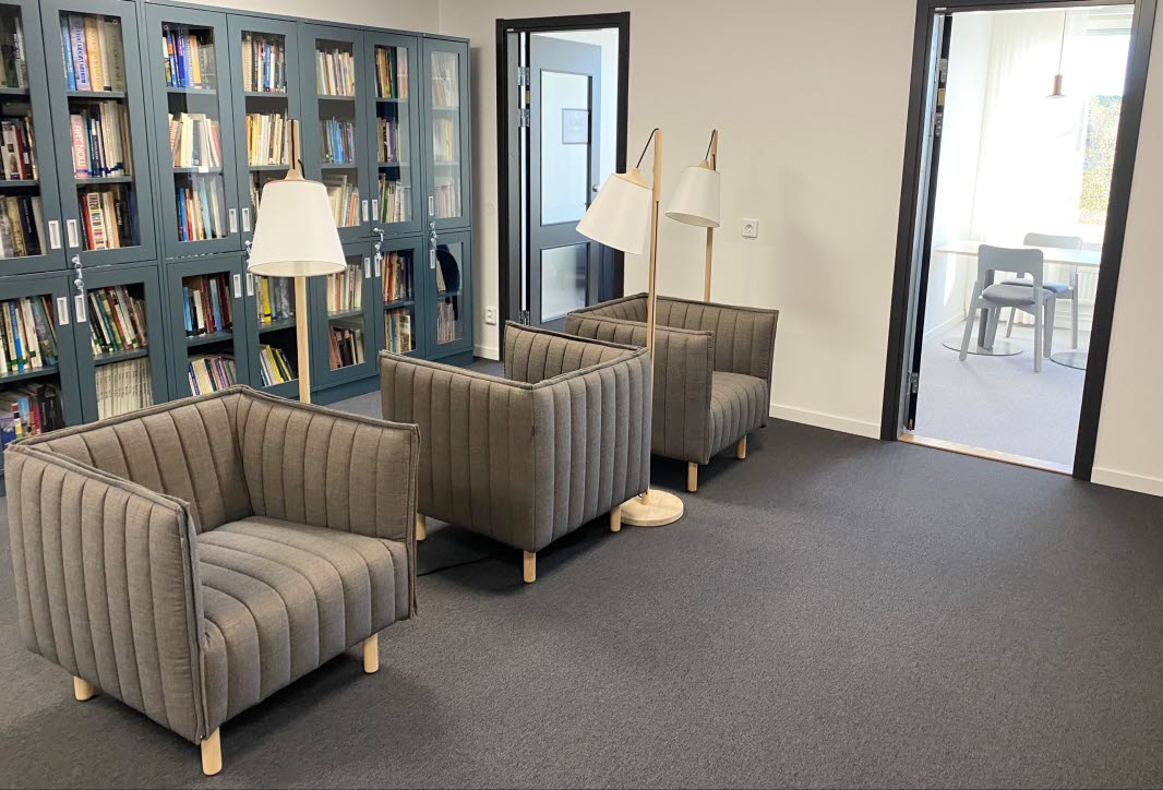 Gray armchairs with and lamps, in the background blue shelves.