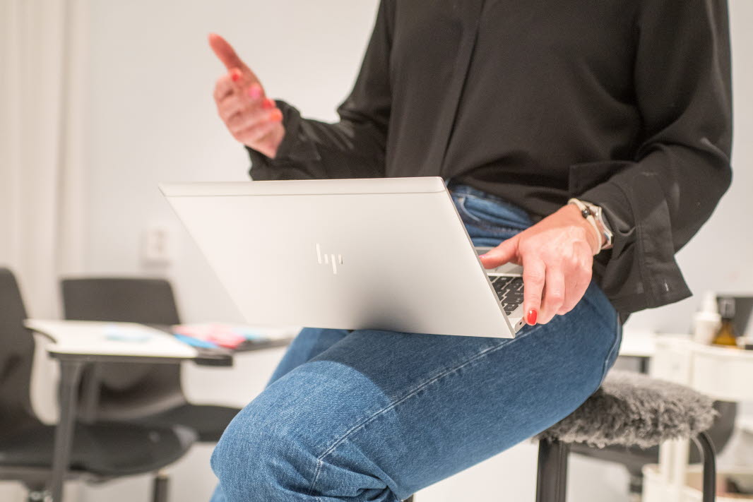 En person med en laptop i knät.