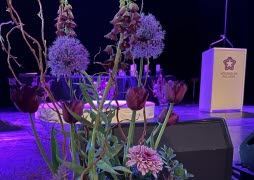 Blommor inomhus talarstol Högskolan Dalarnas logotyp