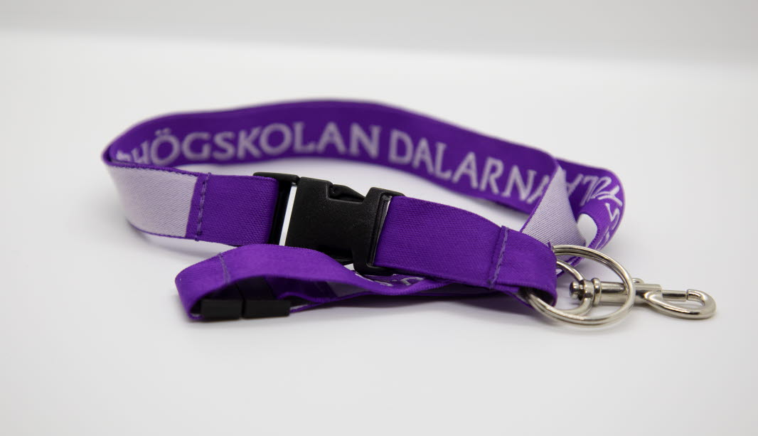 Lila nyckelband med vit text "Högskolan Dalarna".