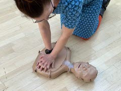 En kvinna utför hjärt-lungräddning på en docka. 